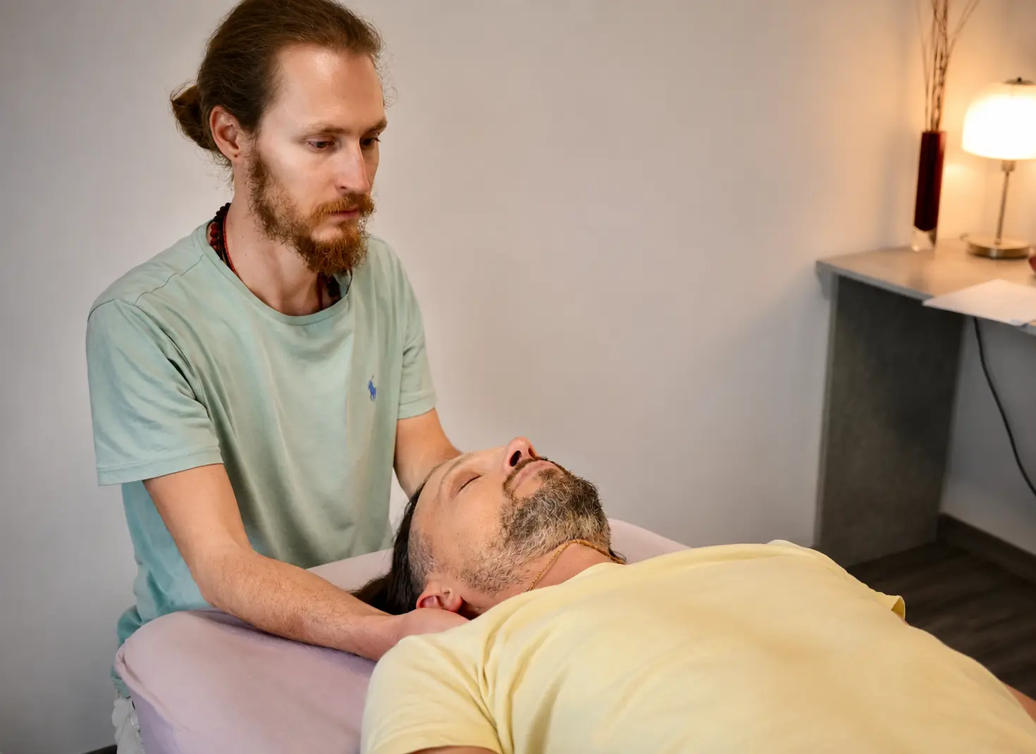 Craniosacral treatment at the head of a patient lying down